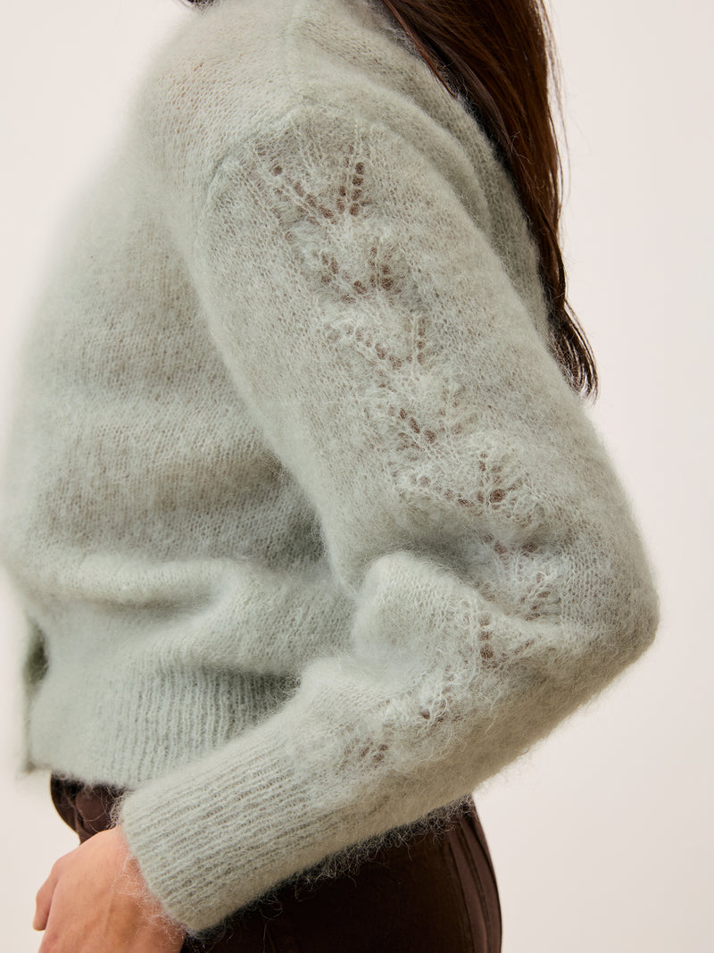Close-up of the sleeves on the Maina cardigan in mint color